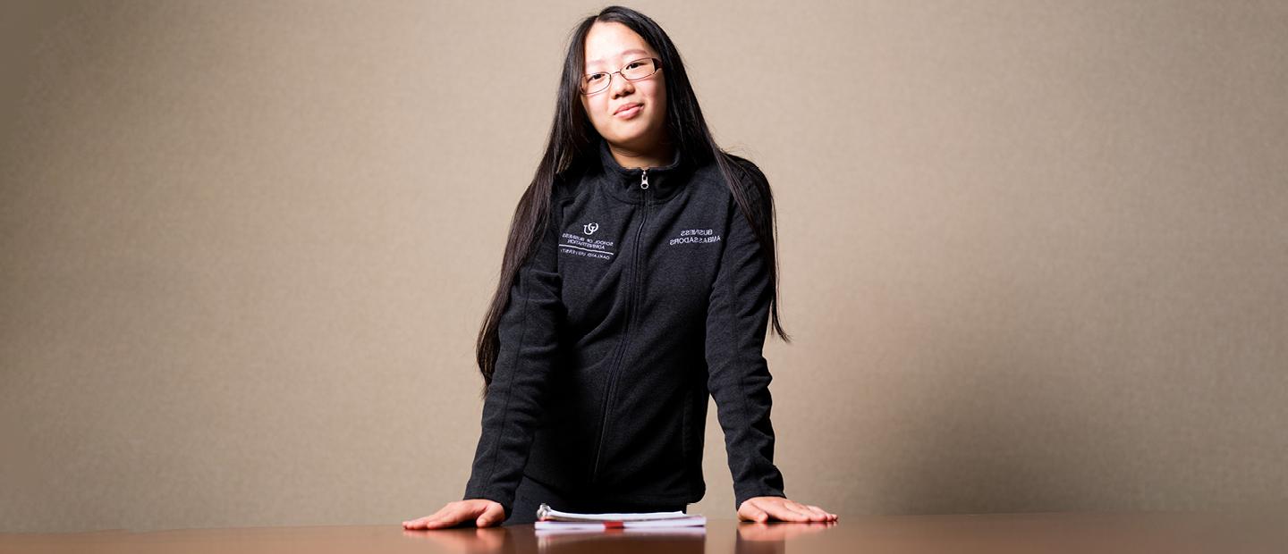 A student standing with their arms crossed